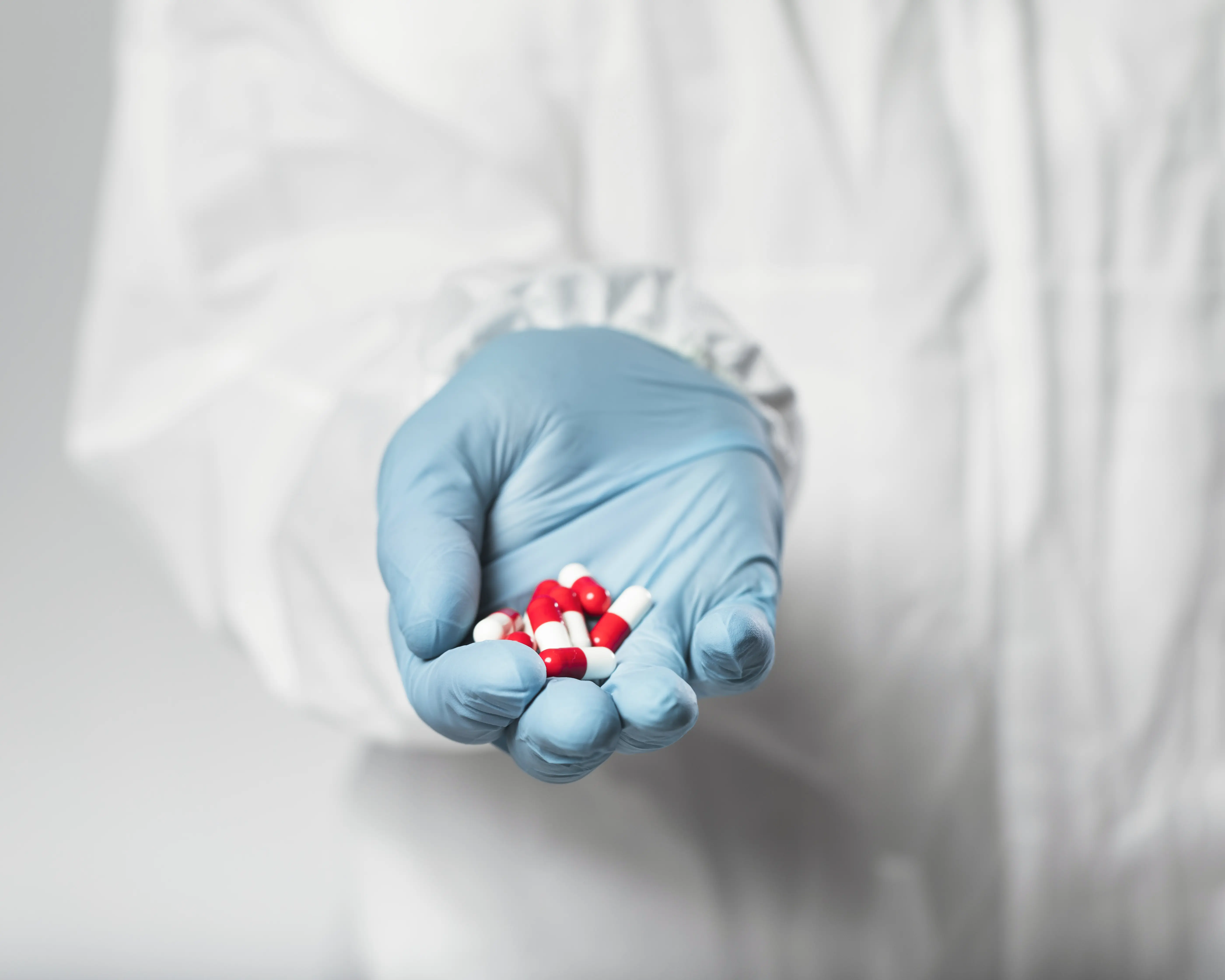 closed hand holding pharmaceutical capsules